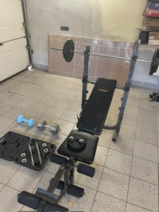 Palestra con bilanciere, diversi pesi e manubri